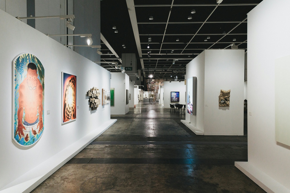 Modern art gallery with white walls and spotlights, showcasing various contemporary artworks